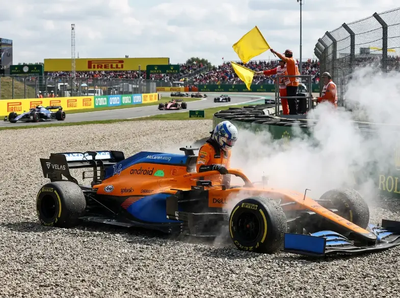 Monolugar de Formula 1 parado na escapatoria com fumo no motor e bandeiras amarelas